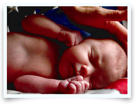 newborn sleeping wrapped in american flag